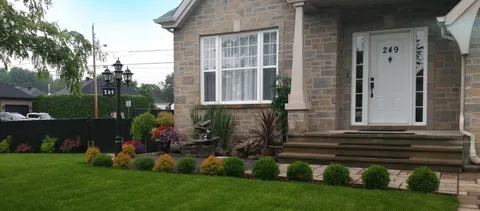 Residence front with entrance steps and planted garden beds.