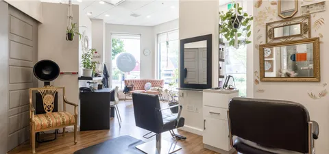 Salon with styling chairs, mirrors, counters and a wash basin