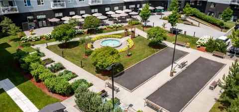 View down into a landscaped courtyard with paths, lawns and garden seating