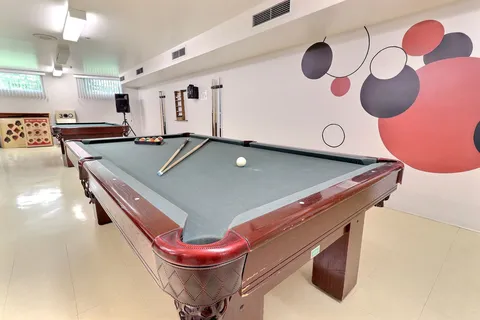 Billiard tables beside a wall painted with coloured circles