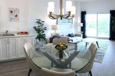 Suite living and dining area with a sofa, round table and kitchen.