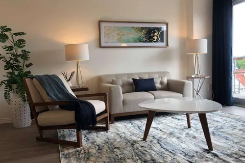 Suite sitting area with a sofa, chairs, rug and side tables.