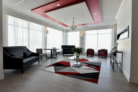Lounge with armchairs, tables and large windows.