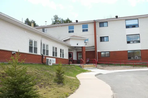 Residence with pale siding and a path leading to the entrance