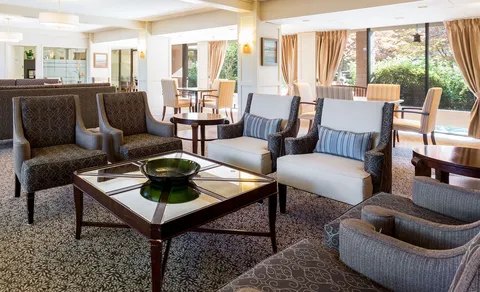 Lounge with upholstered seating, coffee tables and large windows.