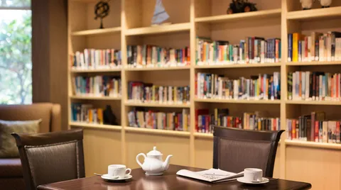 Library shelves behind a table and chairs.