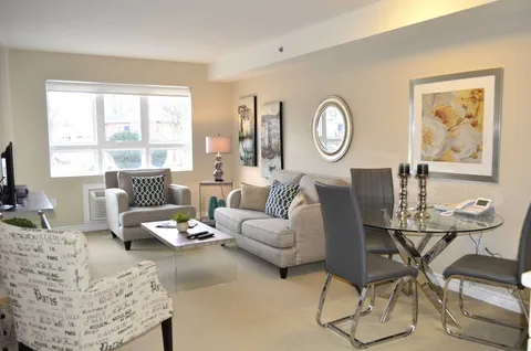 Sitting area with a sofa, armchairs, coffee table and glass dining table