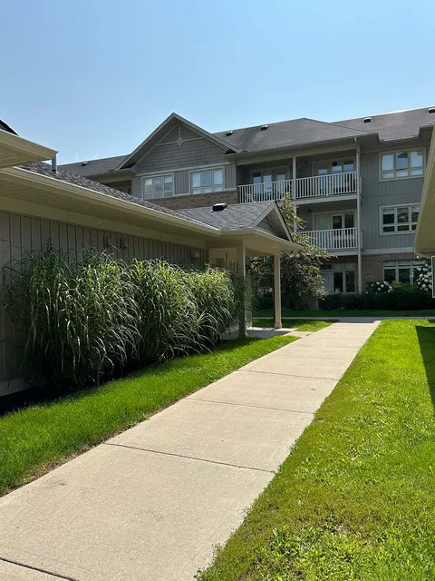 Brick residence and low villas beside a garden path and lawn