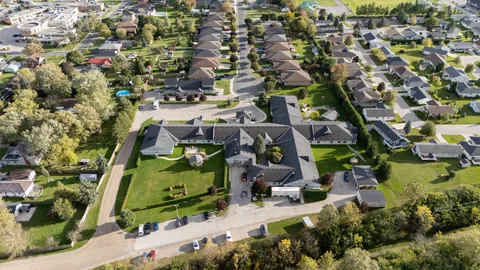 Wide aerial view of a low-rise building and its landscaped grounds