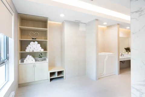 Bathing room with a walk-in bathtub, towel shelves and a vanity