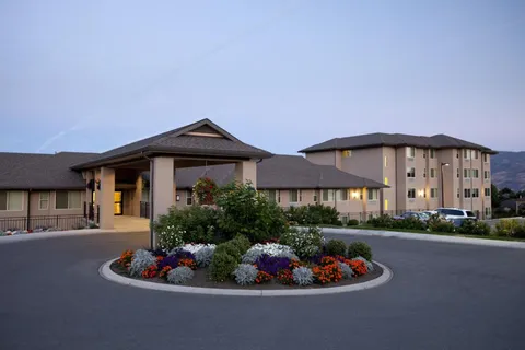 Residence facade and driveway illuminated at dusk