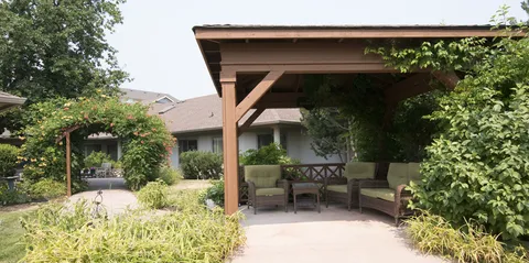 Covered pergola with garden seating and flower beds
