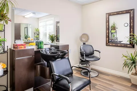 Salon with styling chairs, a hair-washing sink and wall mirrors