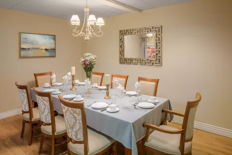 Dining table set for a meal beneath a chandelier