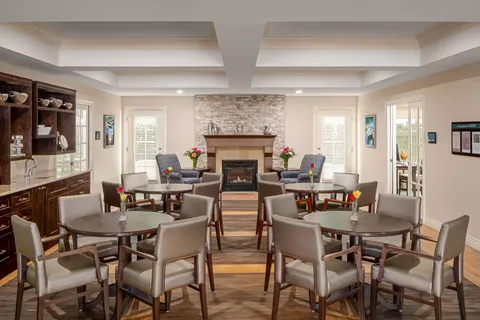 Room with round tables, armchairs and a fireplace
