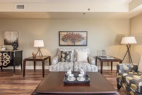 Living room with armchairs, side tables and lamps.