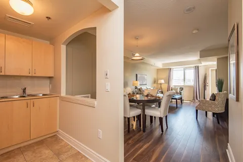 Wood kitchenette beside an adjoining dining and living area.