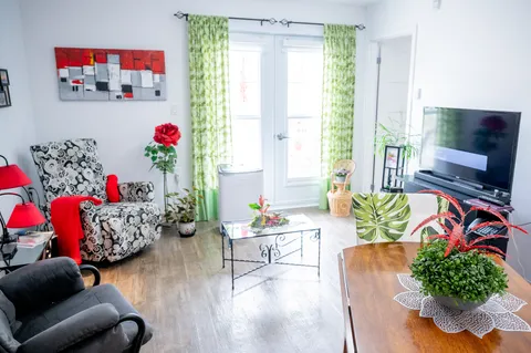 Apartment sitting room with chairs and a television.