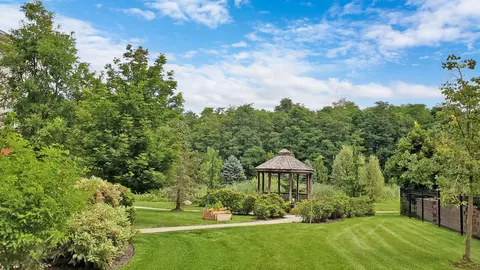 Garden lawn with a wooden gazebo, benches and shrubs
