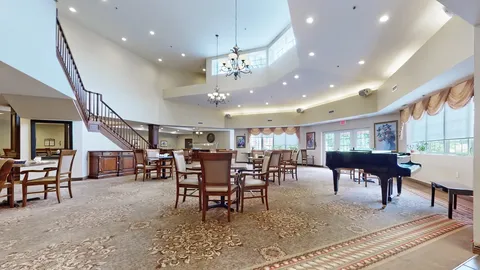 Room with wooden tables, chairs, a piano and hanging lights