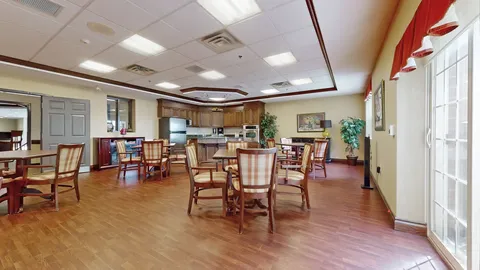 Room with a table, chairs, wooden cupboards and a kitchen counter