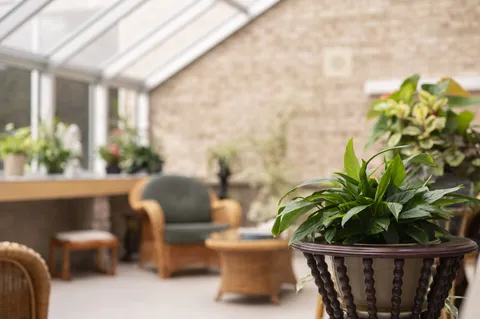 Sunroom with wicker chairs and potted plants