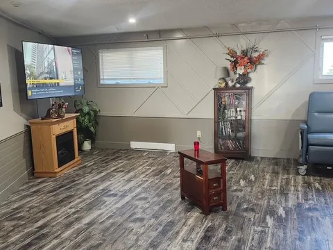 Television room with seating, display cabinets and a coffee table.