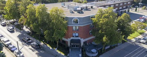 Elevated view of the corner entrance and brick residence.