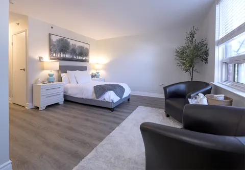 Suite with a bed, dining table and upholstered seating.