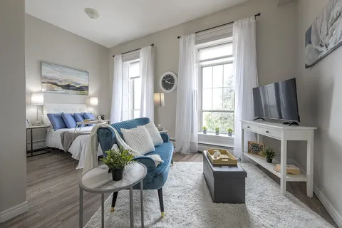 Suite with a bed and furnished sitting area.