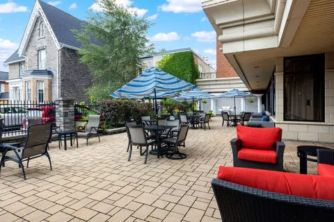 Patio with striped umbrellas, dining tables and red-cushioned chairs
