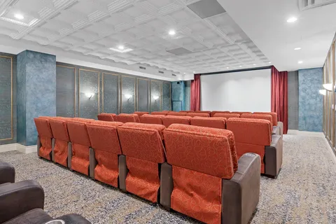 Theatre with rows of red seats facing a blank projection screen