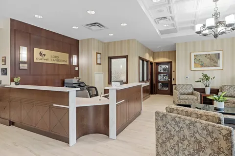 Lobby with a reception counter, patterned armchairs and a chandelier