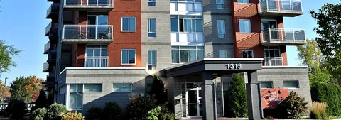 Brick high-rise building with balconies and a covered entrance marked 1313