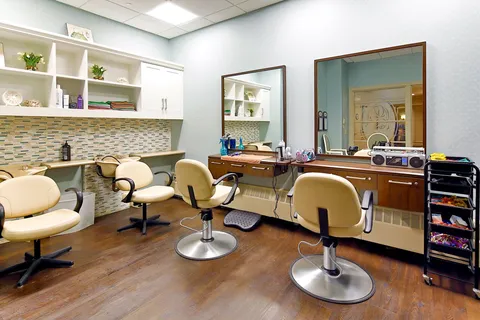 Salon with styling chairs, mirrors and wash basins.