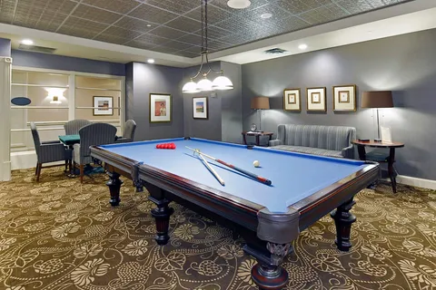 Billiards room with a pool table and seating.