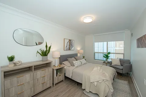Bedroom with a bed, dresser, nightstand and window.