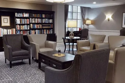 Library lounge with bookshelves and chairs around a coffee table.