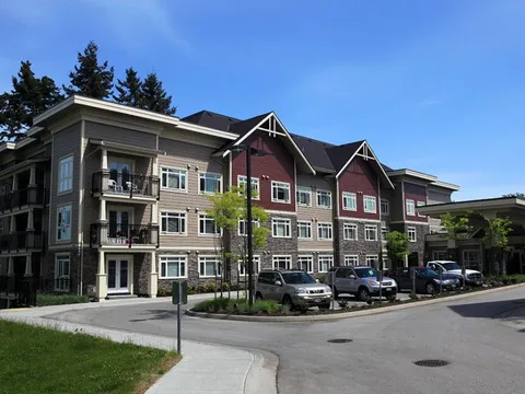 Building frontage with balconies and parking area.