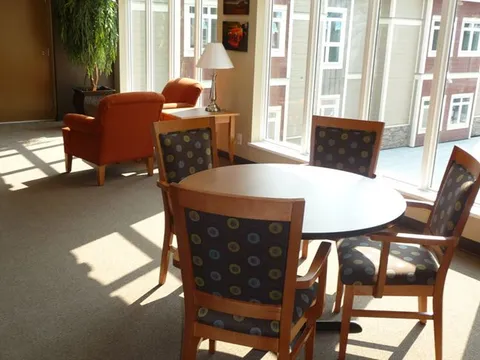 Window-side sitting area with chairs and a round table.