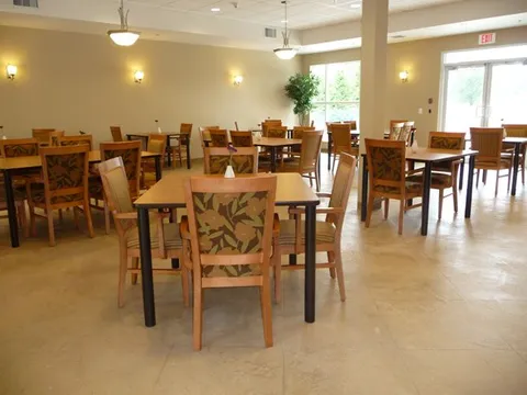 Dining room with wooden tables and floral-patterned chairs.