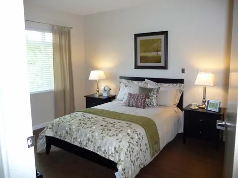 Suite bedroom with double bed, side tables and lamps.