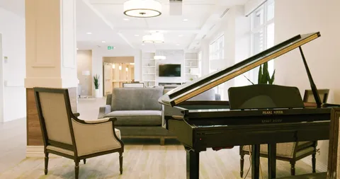 Room with a grand piano, armchair and sofa
