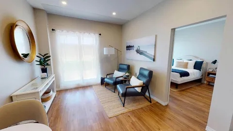Sitting area with two armchairs beside an open bedroom doorway