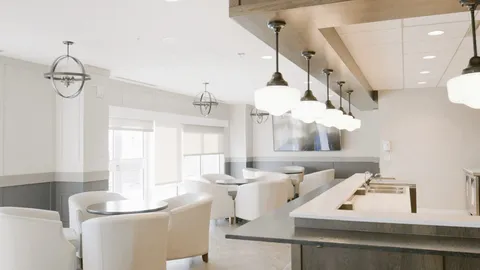 Room with white counters, cushioned chairs and pendant lights