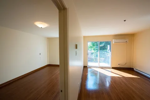 Empty rooms with wood flooring and a sliding balcony door