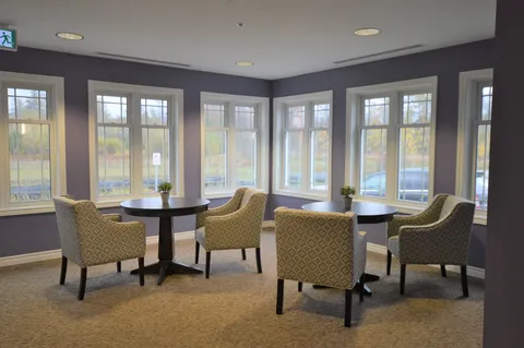 Room with round tables and armchairs beside large windows