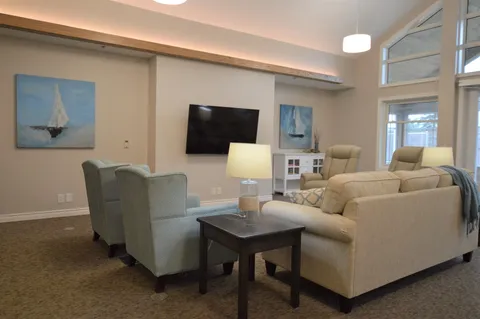 Room with sofas, armchairs, a television and sailing-boat pictures