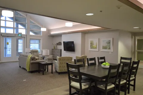 Room with a dining table, armchairs, a sofa and a television