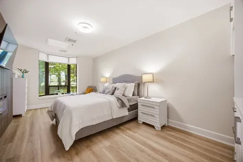 Suite bedroom with a bed, bedside tables and a large window.